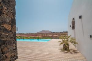 a wooden walkway leading to a pool in a house at Villa Karuna by Aura Collection in Villaverde