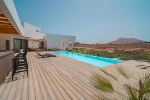 a wooden deck with a swimming pool on top of a house at Villa Karuna by Aura Collection in Villaverde