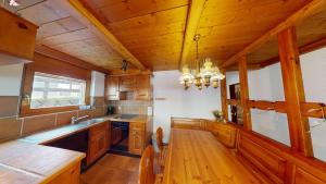 a kitchen with wooden cabinets and a wooden table at Haus Belstar A in Naters