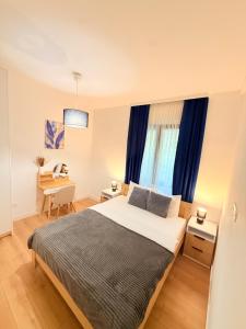 a bedroom with a bed and a desk and a window at Kovacevic Apartments in Kotor