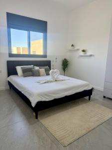 a bedroom with a large bed with a large window at פנטהאוז Siesta in Eilat