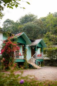 a small green house with a porch and flowers at Mistnview By SHELTERS in Meppādi