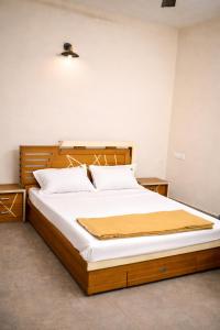 a bedroom with a large bed with white sheets at Mistnview By SHELTERS in Meppādi