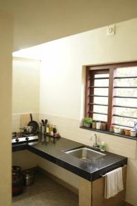 a kitchen with a sink and a window at Mistnview By SHELTERS in Meppādi