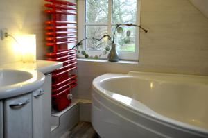 a bathroom with a tub and a sink and a window at Cafe-Kuckuck in Salzwedel