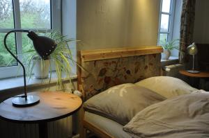 a bedroom with a bed and a lamp on a table at Cafe-Kuckuck in Salzwedel
