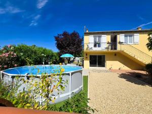 a villa with a swimming pool in front of a house at Le Balcon de Cournon, piscine, jardin, clim à 15 min de plages in Cournonterral