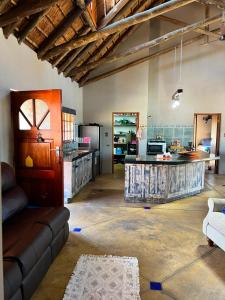 a living room with a couch and a kitchen at Kudu Plaas - Wildlife on your doorstep in Beestekraal