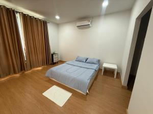 a bedroom with a bed and a table in it at The Hide Private in Ban Non Sa-at