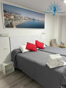 a bedroom with two beds and a picture of a beach at ESTUDIOS CHINASOL - Bernardo Cózar in Almuñécar +70 photos