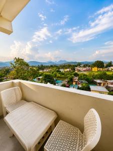 a balcony with a bench and a table and chairs at Hotel Royal Orbit By Arony Hospitality Dehradun in Dehradun