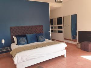 a bedroom with a large bed with blue pillows at Villa Loanaelle in Marrakesh +44 photos