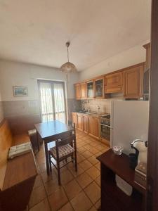 a kitchen with a table and a refrigerator at Casa Pianforte - appartamento per vacanze in Bolsena +27 photos
