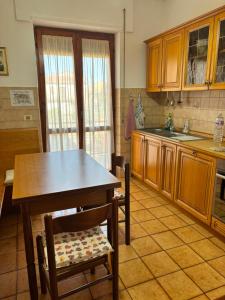 a kitchen with a table and chairs and a sink at Casa Pianforte - appartamento per vacanze in Bolsena