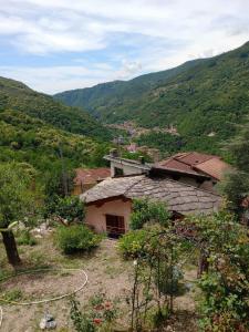 a house on a hill with mountains in the background at La roccia in Mezzanego