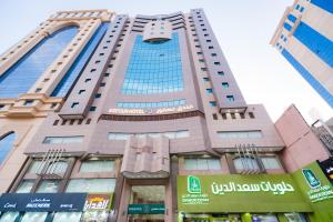 a tall building with a sign in front of it at فندق عصفور 03 in Mecca