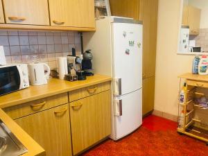 a kitchen with a white refrigerator and wooden cabinets at Appartement vue lac Montreux in Montreux