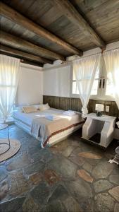 a bedroom with a large bed and two windows at Paros Poolside Cozy Nests - Summer & Salty Getaways in Kalami +99 photos