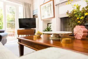 ein Wohnzimmer mit einem Holztisch und einem Fernseher in der Unterkunft Whitebeams in Canterbury