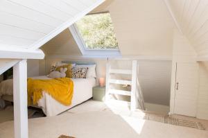 ein kleines Dachzimmer mit Bett und Leiter in der Unterkunft Whitebeams in Canterbury