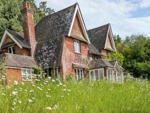 ein altes Backsteinhaus in einem Grasfeld in der Unterkunft Whitebeams in Canterbury