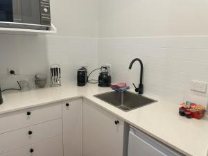 a kitchen counter with a sink and a microwave at Natures Nest near Scenic World in Katoomba
