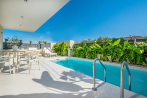 a swimming pool with a table and chairs on a balcony at Calista Horizon by Booking Kottas in Kallithea Halkidikis