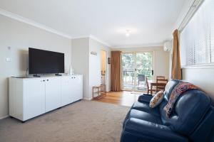 a living room with a couch and a flat screen tv at Natures Nest near Scenic World in Katoomba