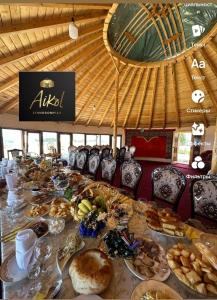 a long table filled with lots of bread and pastries at Айкол Этно Комплекс in Tong
