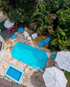 an overhead view of a swimming pool with chairs and umbrellas at Pousada Porto Amazônia in Porto De Galinhas