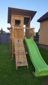 a playground with a slide and a play house at Ferienwohnung Pension Zwethau in Beilrode