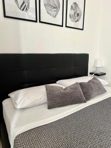 a bed with a black headboard and pillows on it at Modern apartment - Salento Guest House in Monteroni di Lecce