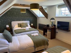 a bedroom with two beds and a tv in a room at The Carpenters Tavern in Dundry +31 photos