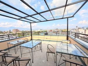 a balcony with tables and chairs on a roof at Hotel Mums Home in Kathmandu