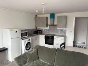 a living room with a couch and a kitchen at Pork pie pad in Melton Mowbray
