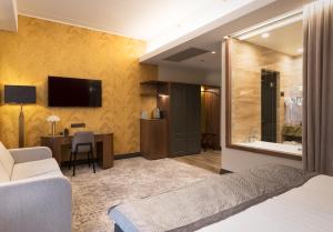 塔爾圖的住宿－V溫泉會議酒店，酒店客房配有一张床、一张书桌和一台电视。
