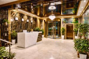a lobby with a counter and potted plants at Hotel Elegant 2 in Andizhan +66 photos