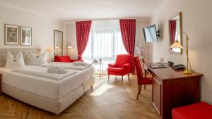 a hotel room with a bed and a desk at Hotel Döllnsee-Schorfheide in Templin