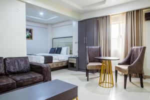 ein Hotelzimmer mit Bett, Sofa und Stühlen in der Unterkunft Romeneo Grand Royal Hotel in Lagos + 16 Fotos