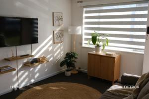 a living room with a flat screen tv next to a window at Harbour Lane Stay in Geraldton