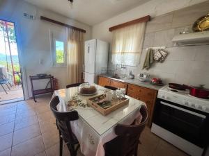 a kitchen with a table and a white refrigerator at Georgaras Accommodation in Platanoússa