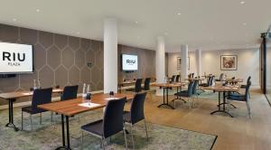 a conference room with tables and chairs and a screen at Riu Plaza London The Westminster in London