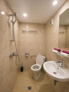 a bathroom with a toilet and a sink and a shower at Family Hotel Yulian in Kranevo