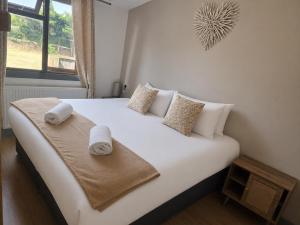 a bedroom with a large white bed with towels on it at The Godwins in Hereford