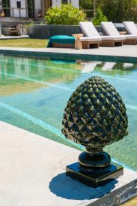 a pineapple statue in front of a swimming pool at Quinta da Boa Esperança in Torres Vedras