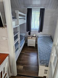 a small room with two bunk beds and a desk at Domki Letniskowe Do-Iwi in Ustronie Morskie +24 photos