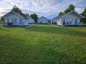 a row of white houses in a field of grass at Domki Letniskowe Do-Iwi in Ustronie Morskie