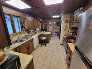 a large kitchen with wooden cabinets and a sink at Wine and roses farm house in Waymart