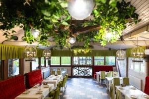 a restaurant with tables and chairs and chandeliers at Hotel Restaurant Vizit in Truskavets