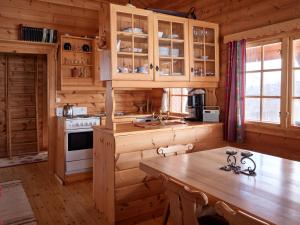 a kitchen with wooden cabinets and a table in a cabin at Fjellro in Stranda